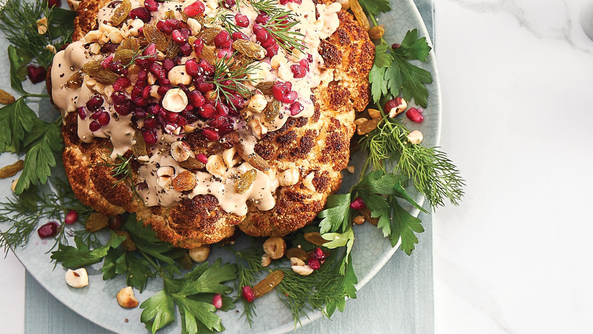 Whole Roasted Cauliflower with Pomegranate Tahini Sauce, Raisins