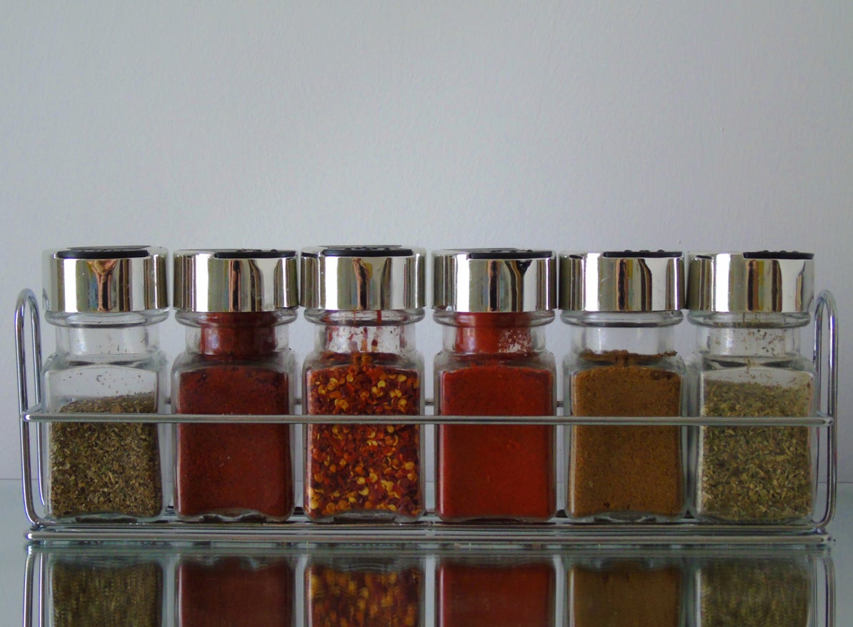 Spice rack full of different herbs and spices (Basil, Mixed Herbs, Cumin, Chilli Flakes, Paprika and Powdered Chilli)