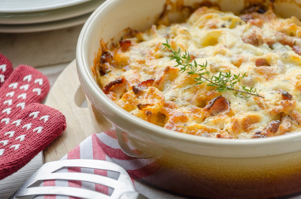 Cheese-topped potato bake containing heavy cream, chicken, bacon onion and thyme ready to serve