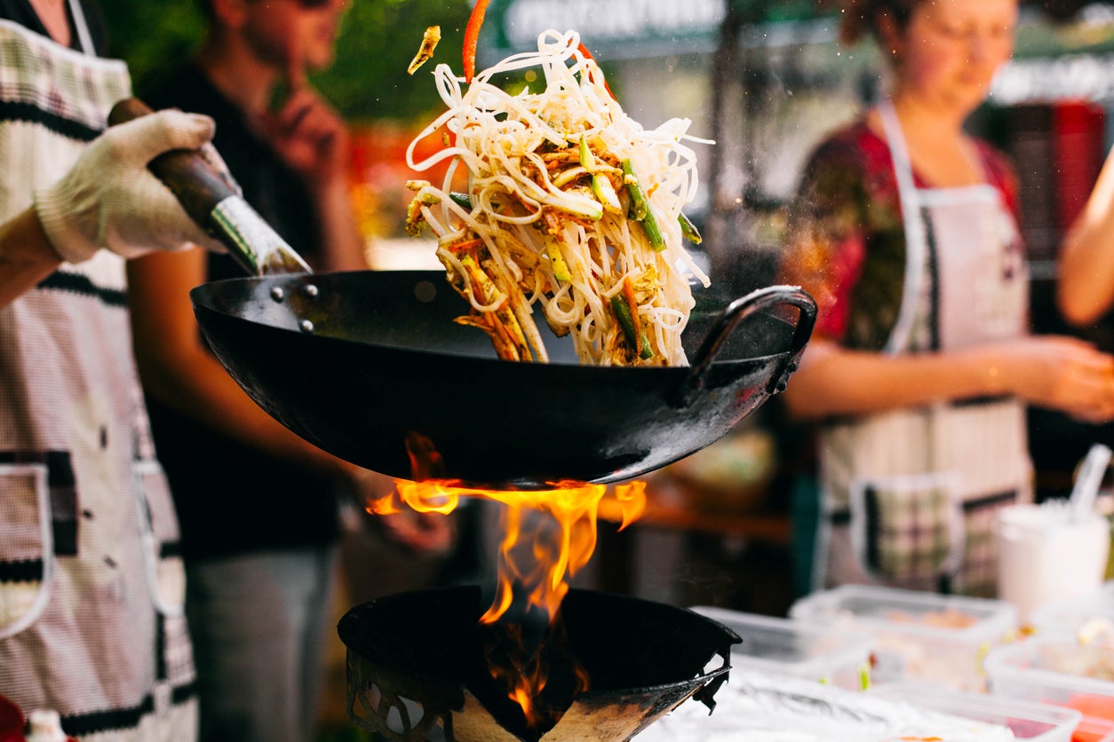 Man cooks noodles on the fire
