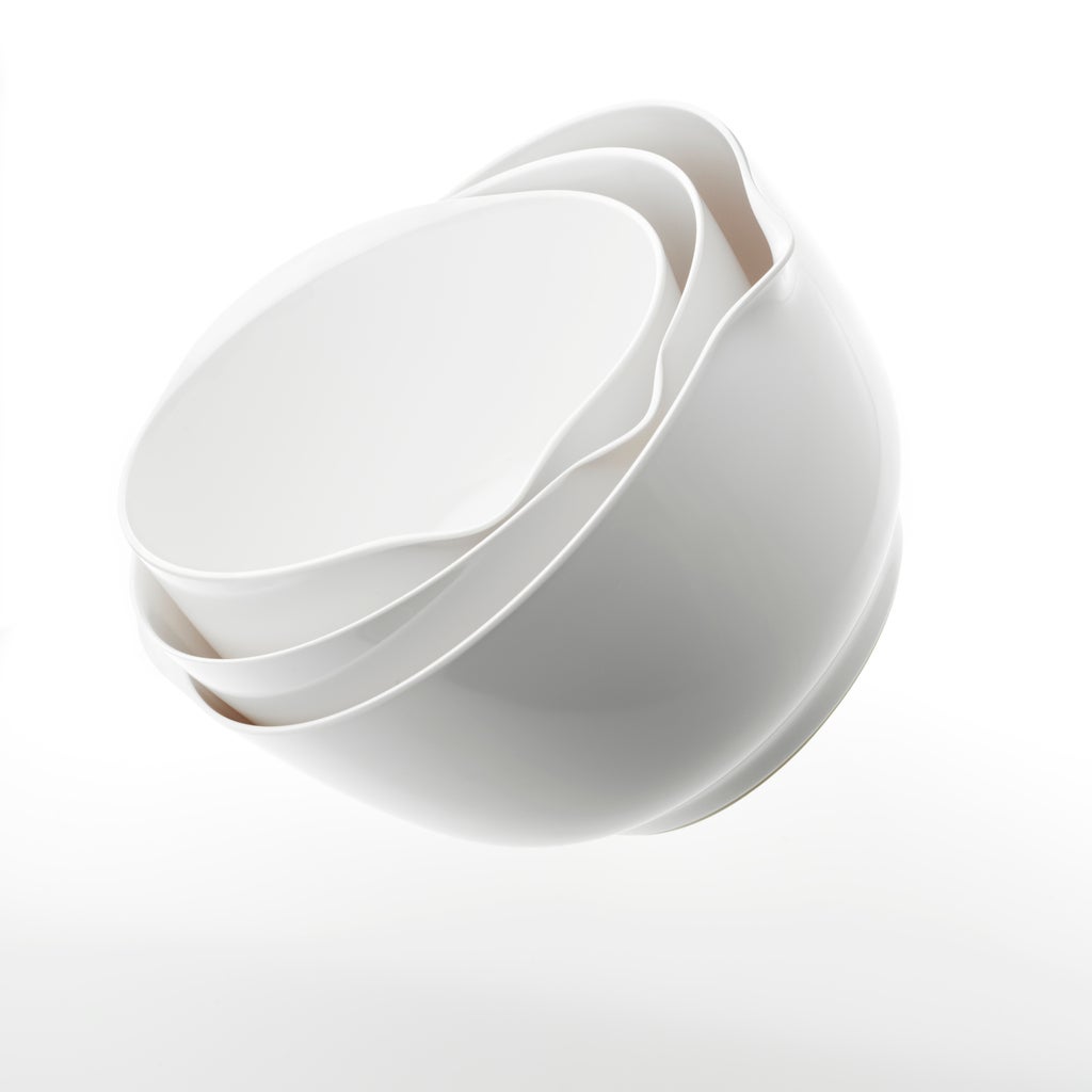 Three nesting white mixing bowls on a white background with gradated shadow.