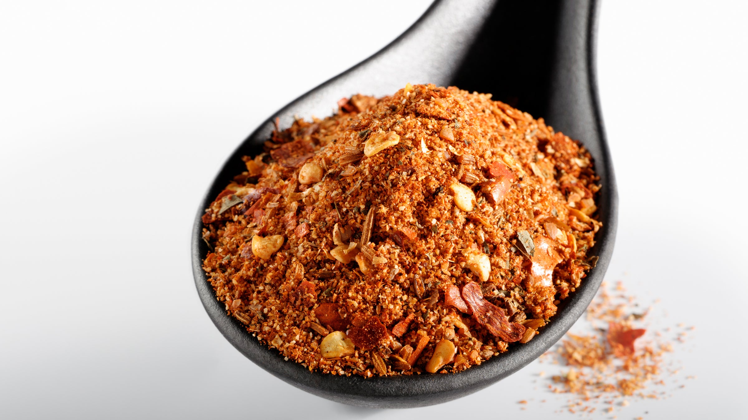 Spoonful of ground spices on white