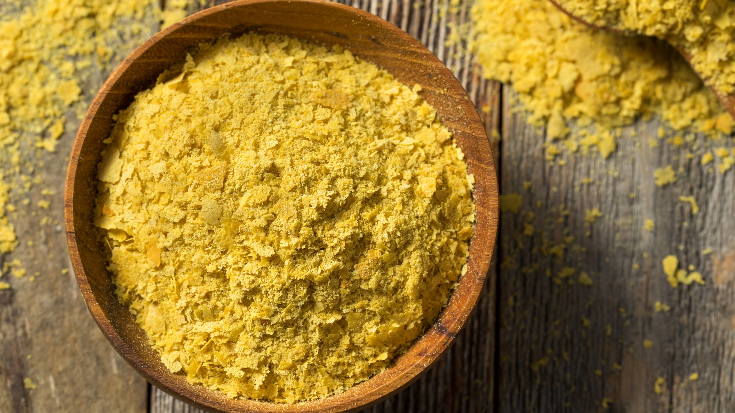 Bowl of nutritional yeast on wood