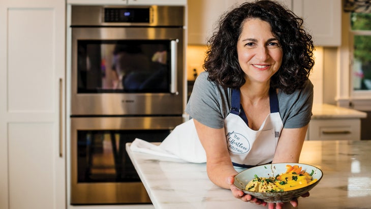 Chef Debbie Brosnan holds a bowl in a kitchen