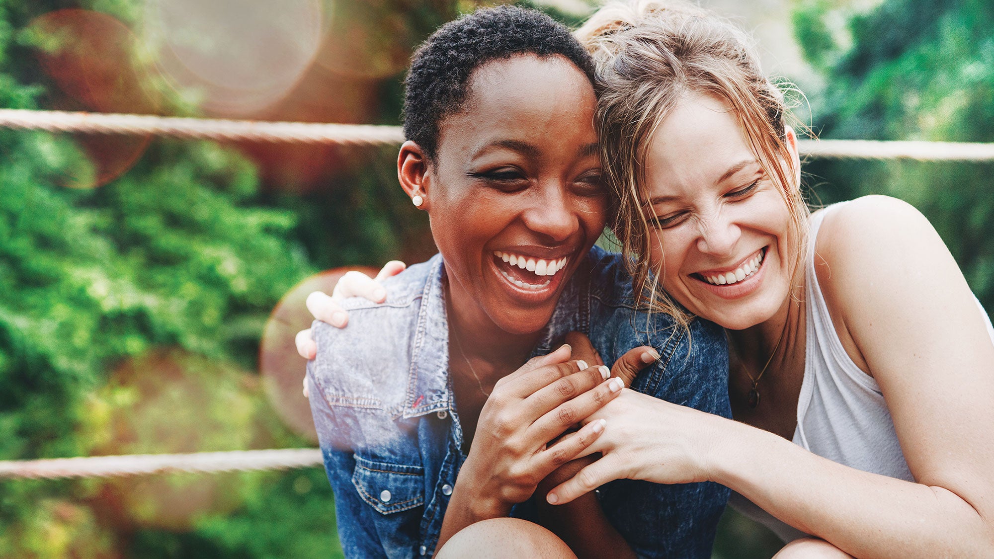 Two women laughing and holding each other